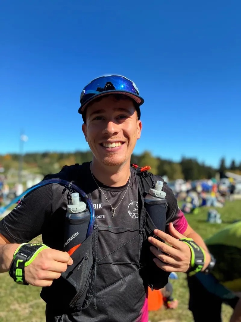 Enzo Leveque en tenue de trail, devant un ciel bleu.
